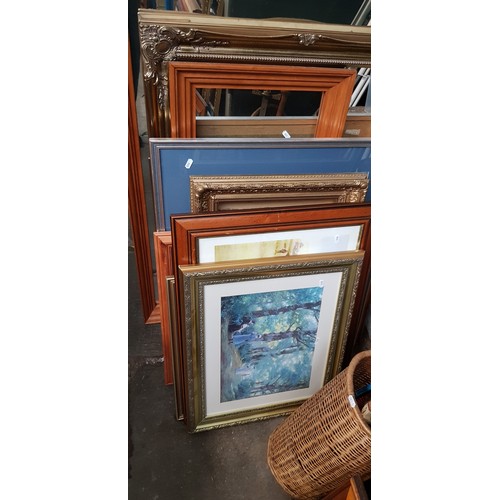 394 - A quantity of pictures and mirrors with some having gilt frames