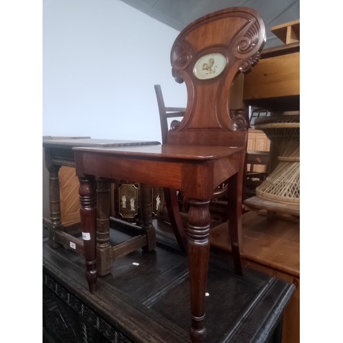 908 - A 19th century mahogany hall chair with lion decoration to back.