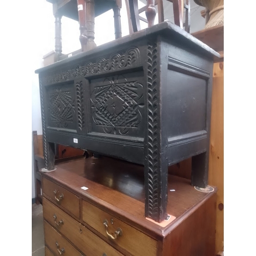 910 - An 18th century carved oak coffer.