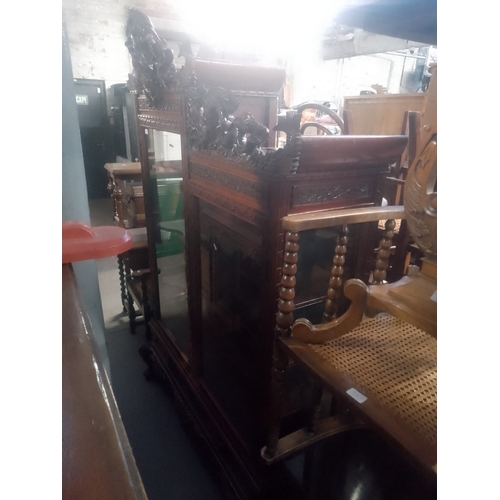 940 - A Chinese heavily carved hardwood display cabinet decorated with dragons.