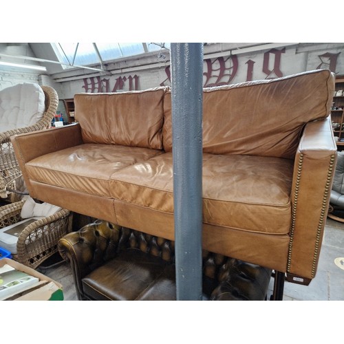 979 - A tan leather sofa.