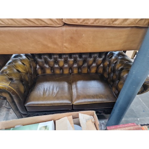 980 - A brown leather Chesterfield sofa.