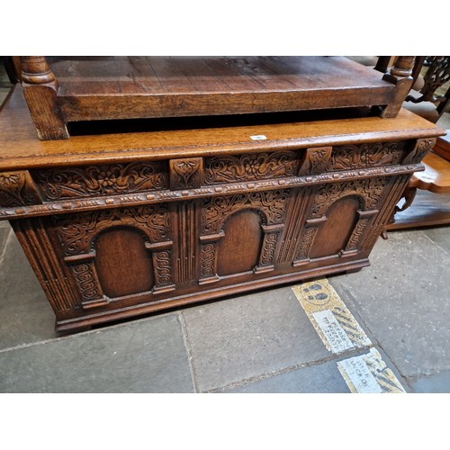 967 - A aged oak coffer with carved panels.