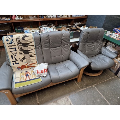 984 - An Ekornes Stressless grey leather two seater sofa and matching swivel armchair.