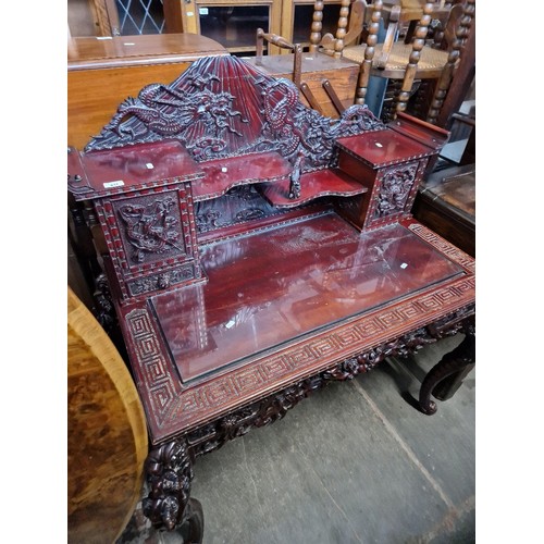 947 - A Chinese heavily carved hardwood desk decorated with dragons.