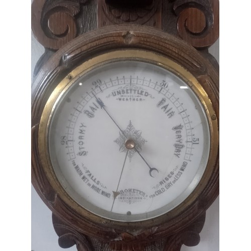 750 - A Victorian carved oak barometer with clock.