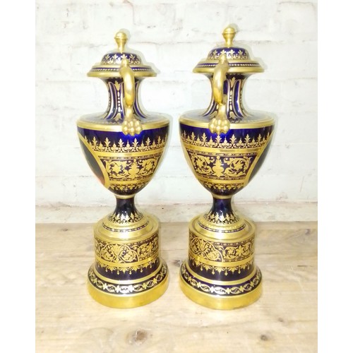 265 - A large pair of 'Vienna' porcelain urns, gilt decoration on blue ground with painted panels entitled... 