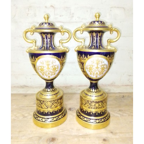 265 - A large pair of 'Vienna' porcelain urns, gilt decoration on blue ground with painted panels entitled... 