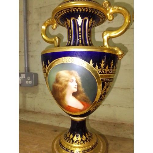 265 - A large pair of 'Vienna' porcelain urns, gilt decoration on blue ground with painted panels entitled... 