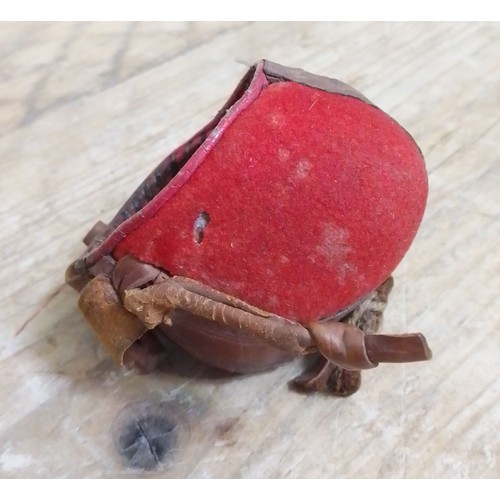 260 - A 19th century leather and red fabric falconry hood, length 6.5cm.