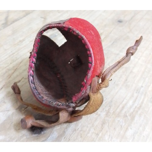 260 - A 19th century leather and red fabric falconry hood, length 6.5cm.