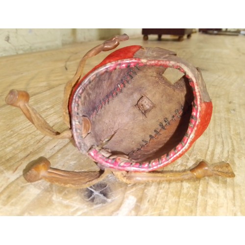 260 - A 19th century leather and red fabric falconry hood, length 6.5cm.