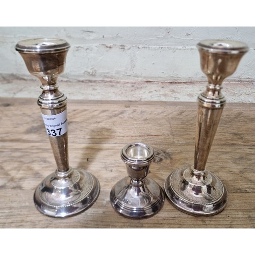 337 - A pair of silver candlesticks, Birmingham, AT Cannon Ltd, 1969 together with another candlestick.