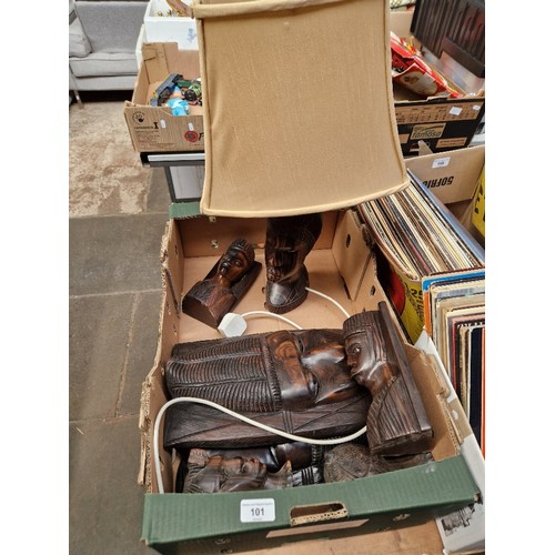 101 - A box of treen, masks, carved figures and a figural lamp.