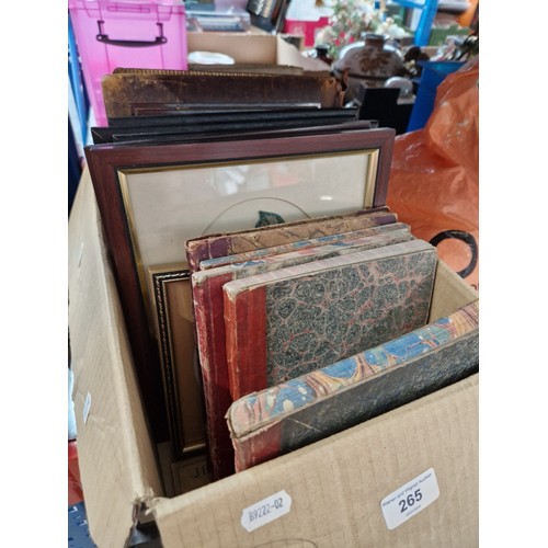 265 - A box containing framed and glazed embroidered flowers, together with 19th century books (one dated ... 