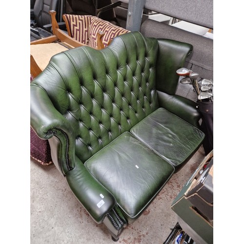 941 - A green leather Chesterfield Queen Anne style two seater settee.