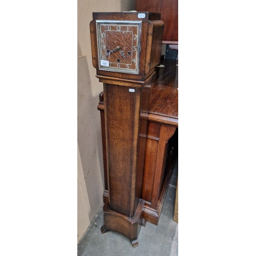 958 - A 1930s oak cased chiming Granddaughter clock with pendulum and key.