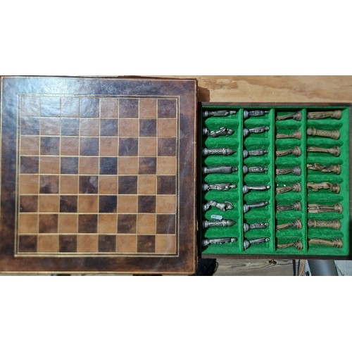 337 - A tooled leather chess board, with cast metal chess pieces in fitted drawer.