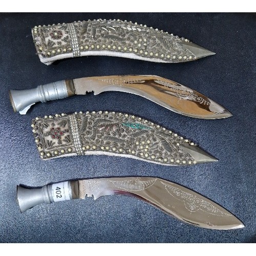 402 - A pair of Eastern Kukri style knives with decorative sheaths.