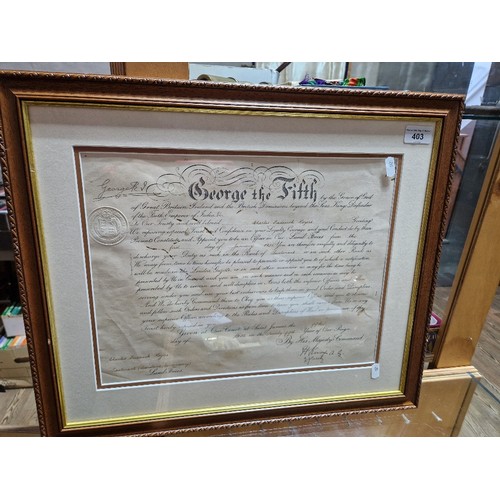 403 - A framed WWII military document signed by George V and dated 1935, certifying Charles Frederick Roge... 