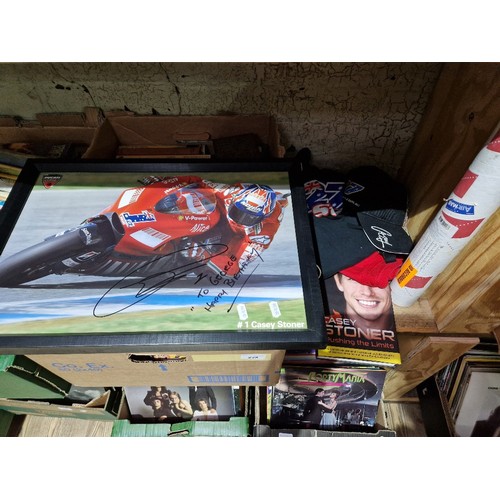 393 - A group of Casey Stoner motorcycle racer memorabilia to include signed pictures (one glazed & framed... 