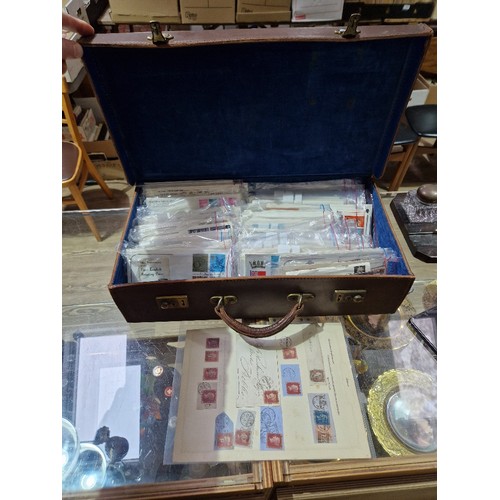 409 - A vintage case containing assorted stamps and first day covers.