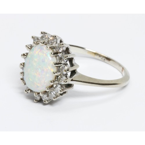 43 - An opal and diamond cluster ring, the oval opal cabochon measuring approximately 12.58mm x 9.93mm, d... 