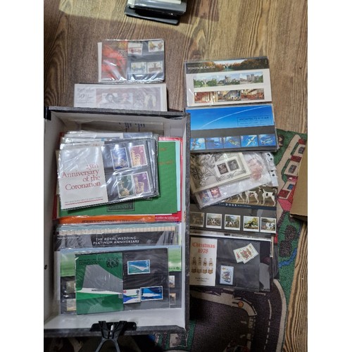 253 - A box of assorted mint presentation packs and FDCs etc.