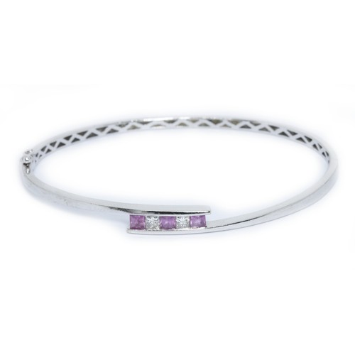 100 - An 18ct white gold diamond and pink sapphire bangle, sponsor 'BD', Sheffield 2009, diameter approxim... 