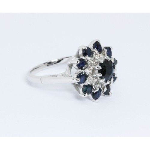 124 - A diamond and sapphire cluster ring, the cluster measuring approximately 16mm in diameter, white met... 