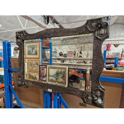 773 - An early 20th century pewter framed wall mirror.