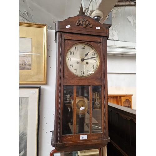 817 - An early 20th century oak cased wall clock.