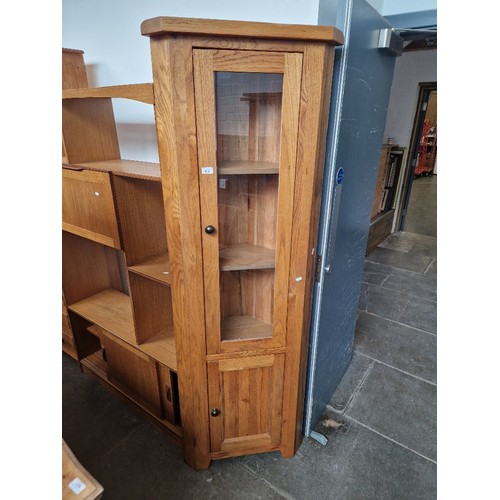 919 - A modern oak corner cabinet.