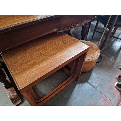 907 - A mixed lot comprising mid 20th century teak nest of tables, retro leather pouffe and a floor standi... 