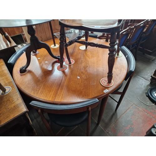 912 - A mid 20th century G Plan teak extending dining table and four chairs.