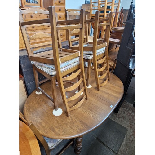 930 - An Ercol elm extending dining table and six chairs.