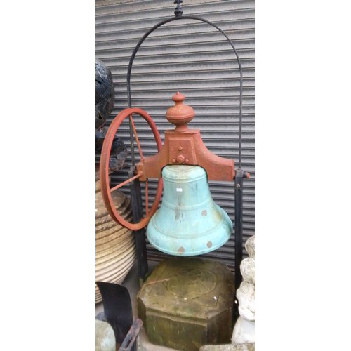 244 - A very large bronze bell on a metal frame with a large stone base and metal wheel