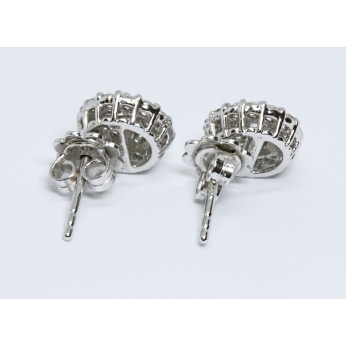 145 - A pair of 18ct white gold diamond cluster earrings, each cluster formed from 21 round brilliant cut ... 