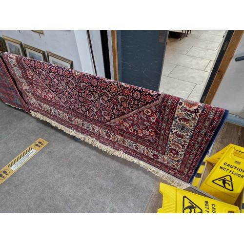 858A - A Persian style wool carpet, red ground, made in Belgium, 200cm x 300cm (approx).