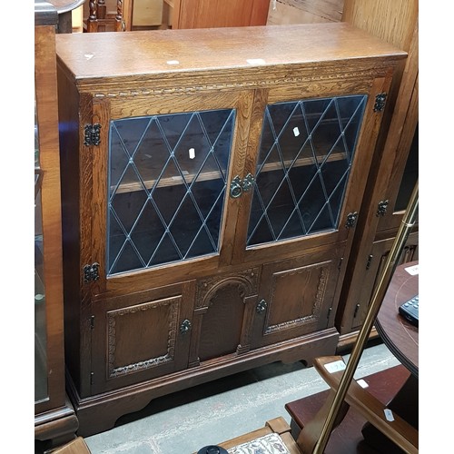 957 - An oak bookcase with leaded glass doors.