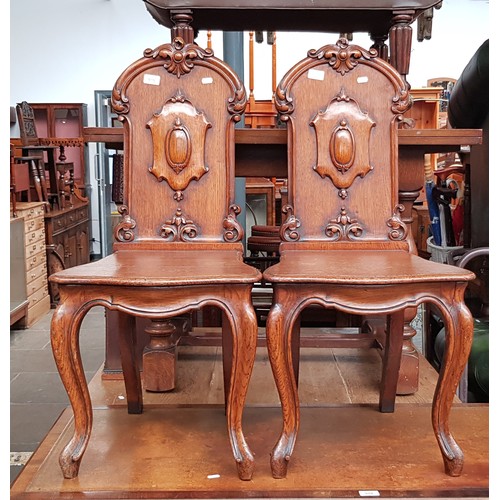 979 - A pair of 19th century oak hall chairs with cabriole legs.