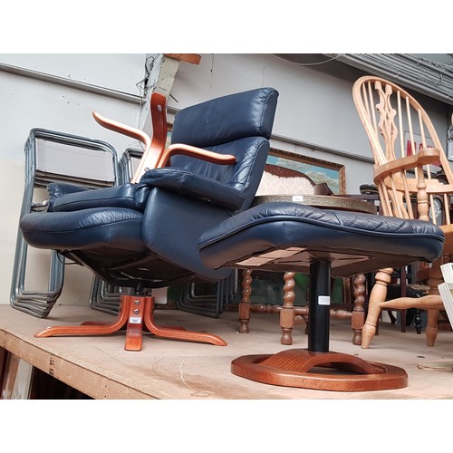 980 - Two Swedish leather swivel lounge chairs with stools.