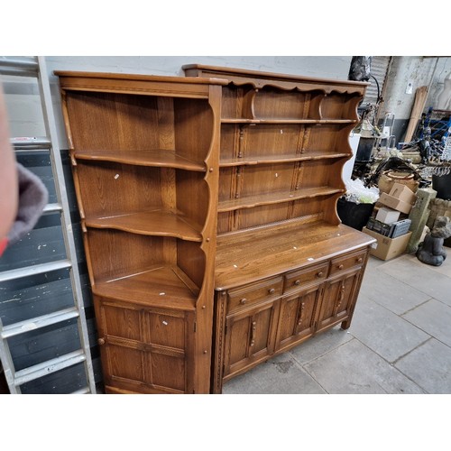 994 - An Ercol elm dresser with plate rack back, together with a matching corner cabinet.