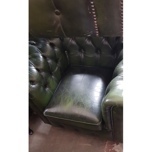 977 - A green leather Chesterfield suite comprising three seater sofa, club chair, wingback armchair and f... 