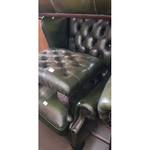 977 - A green leather Chesterfield suite comprising three seater sofa, club chair, wingback armchair and f... 