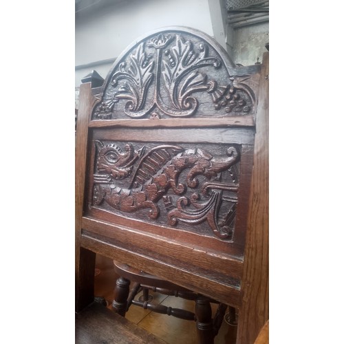 902 - An 18th century carved oak chair with dragon to the back.