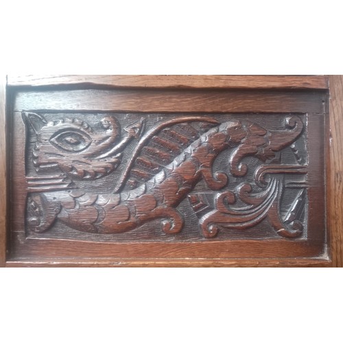 902 - An 18th century carved oak chair with dragon to the back.