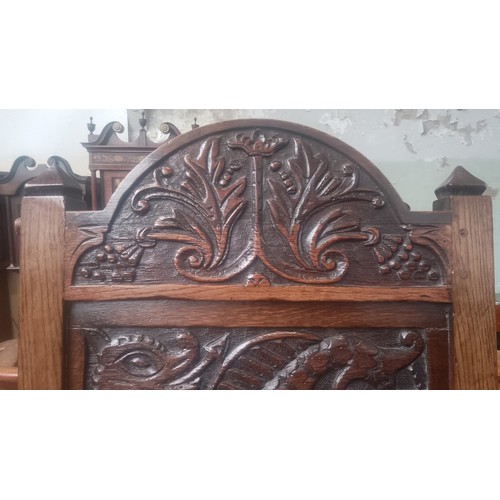 902 - An 18th century carved oak chair with dragon to the back.