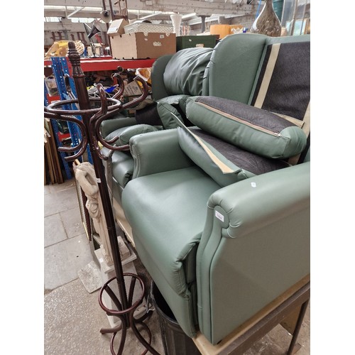 1004 - A pair of green leather electric recliner armchairs.