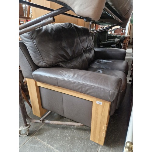 1005 - An oak and brown leather two seater sofa.